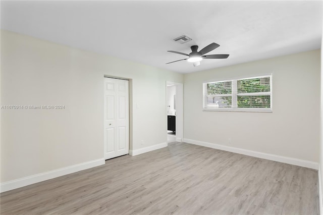 unfurnished bedroom featuring ceiling fan, light wood-type flooring, and a closet