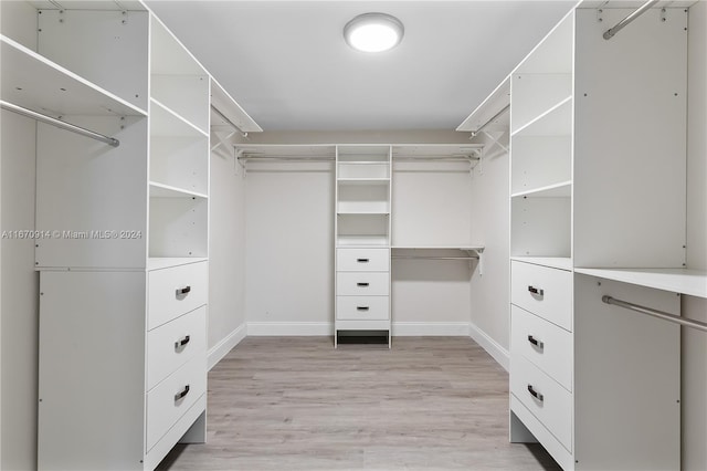 walk in closet with light hardwood / wood-style flooring