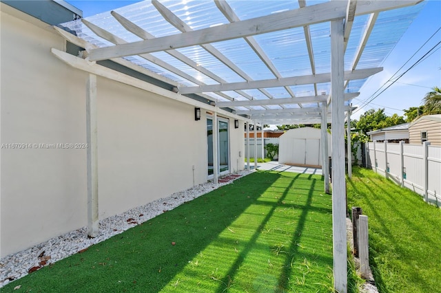 view of yard featuring a pergola and a storage unit