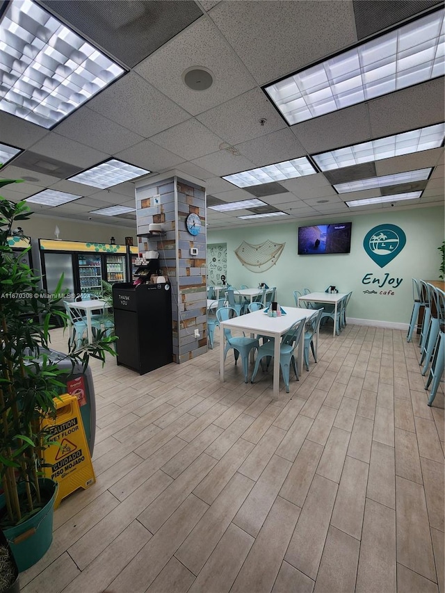 dining room featuring hardwood / wood-style flooring and a drop ceiling