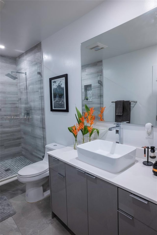 bathroom featuring toilet, vanity, and walk in shower