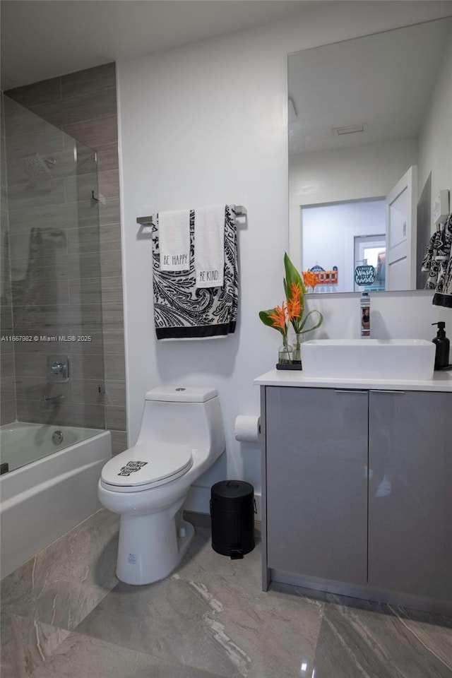 full bathroom with toilet, vanity, and tiled shower / bath combo