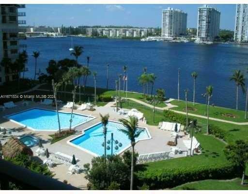 view of pool with a patio and a water view