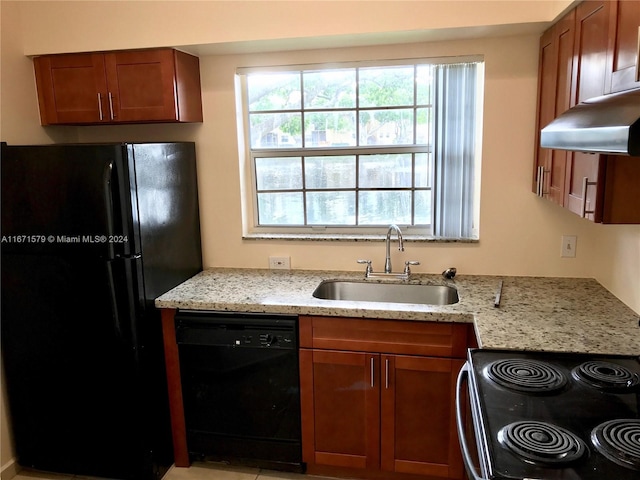 kitchen featuring black appliances, light stone counters, and sink