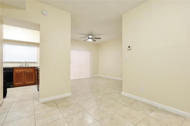 unfurnished room with ceiling fan, light tile patterned flooring, and sink