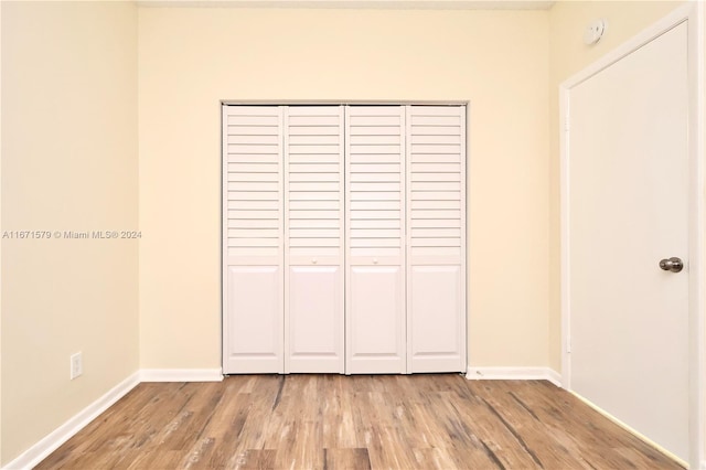 unfurnished bedroom with wood-type flooring and a closet