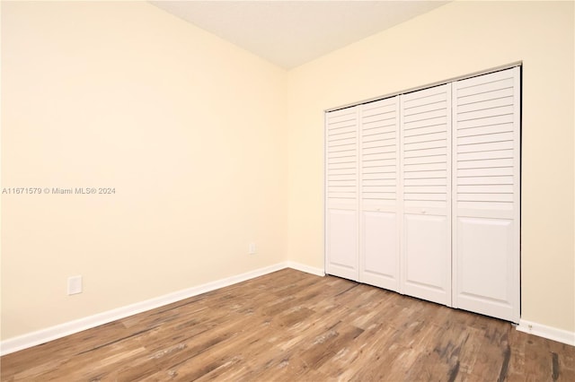 unfurnished bedroom featuring wood-type flooring and a closet