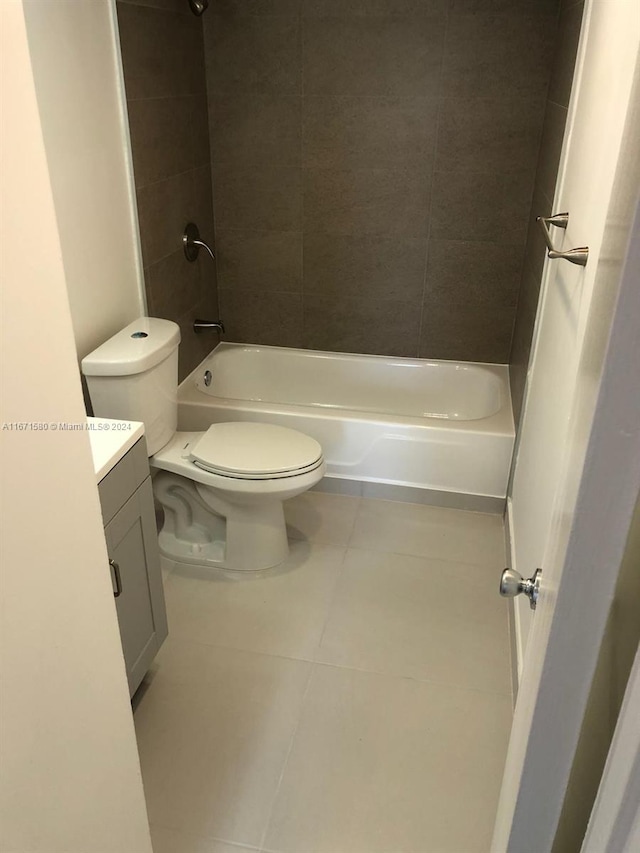 full bathroom featuring tiled shower / bath combo, vanity, tile patterned flooring, and toilet