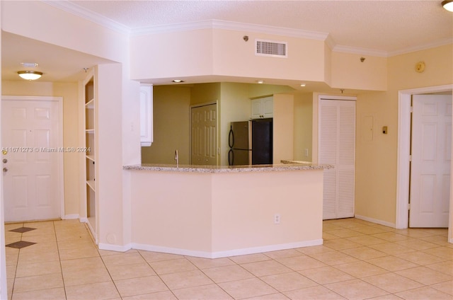 kitchen featuring white cabinets, stainless steel fridge, light tile patterned floors, kitchen peninsula, and crown molding