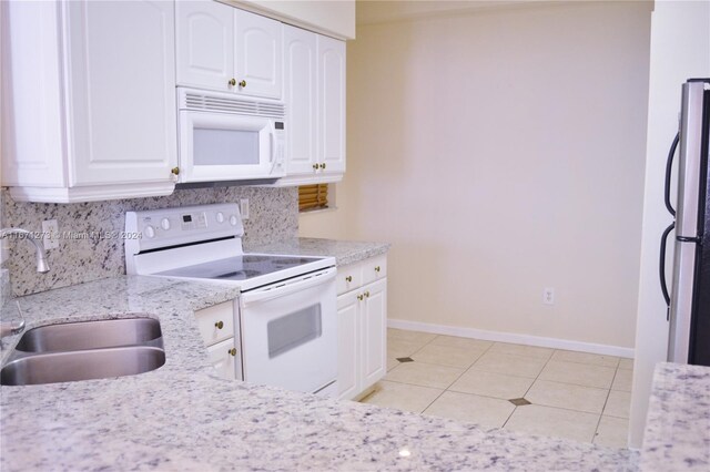 kitchen with white appliances, white cabinets, decorative backsplash, and a sink