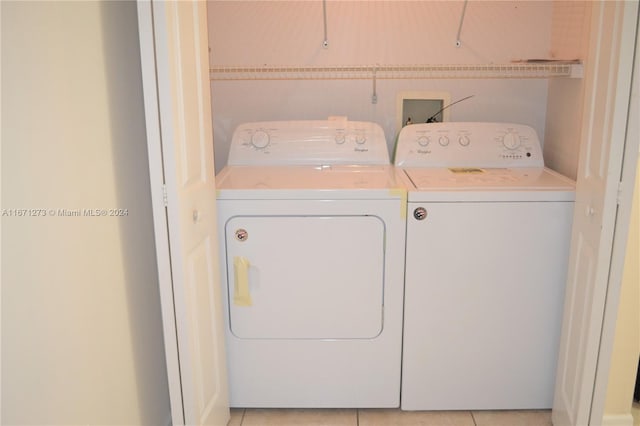 clothes washing area featuring light tile patterned floors and independent washer and dryer