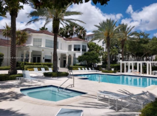 view of pool featuring a patio and a hot tub