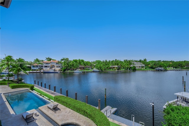 view of swimming pool featuring a dock, a patio, a water view, and a hot tub