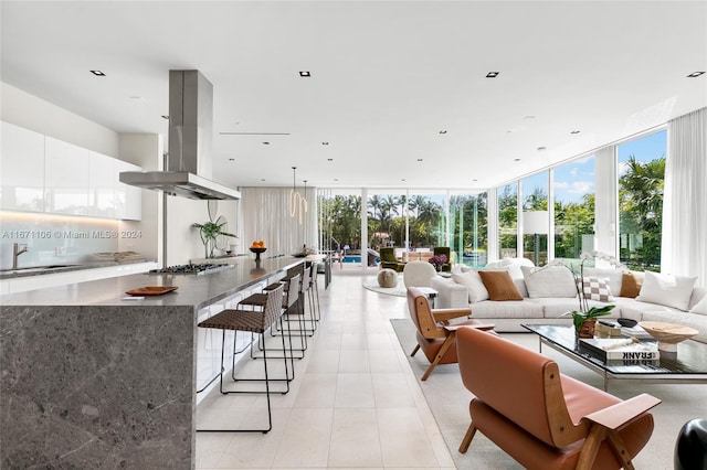 interior space featuring light tile patterned flooring, a wall of windows, and sink