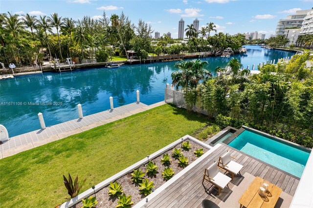 view of swimming pool with a lawn and a water view