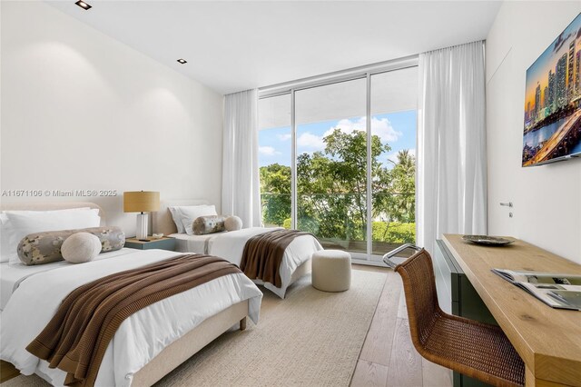 bedroom featuring hardwood / wood-style floors and floor to ceiling windows