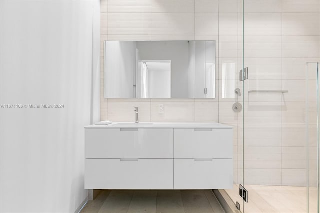 bathroom featuring vanity, decorative backsplash, and a shower with shower door