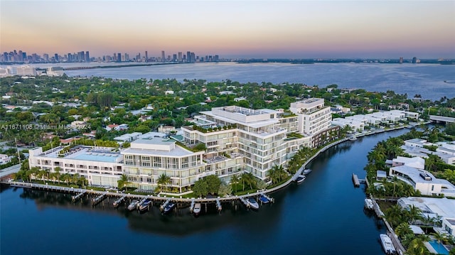 aerial view at dusk featuring a water view