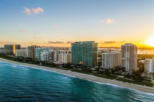 aerial view at dusk with a view of the beach and a water view