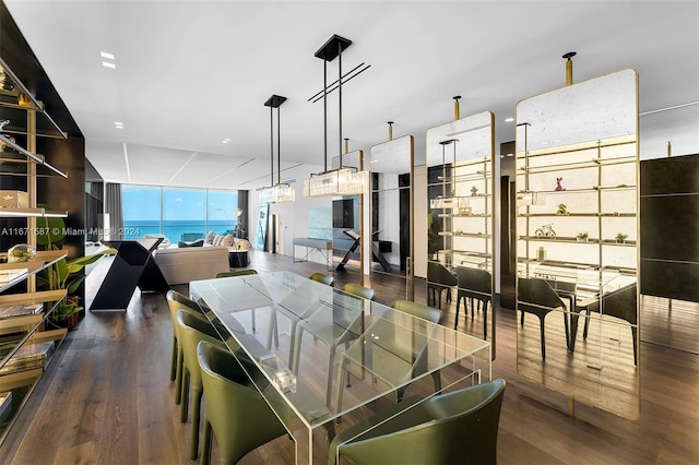 dining room featuring a wall of windows, dark hardwood / wood-style floors, and a water view