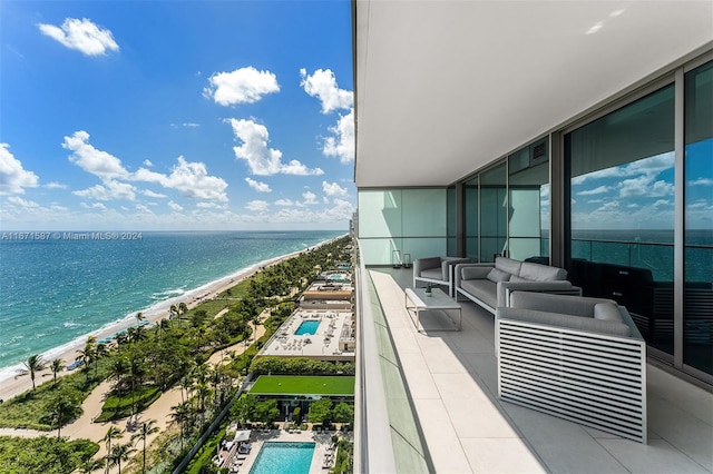 balcony with a water view, an outdoor living space, and a beach view