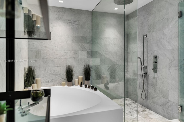 bathroom featuring plus walk in shower and tile walls