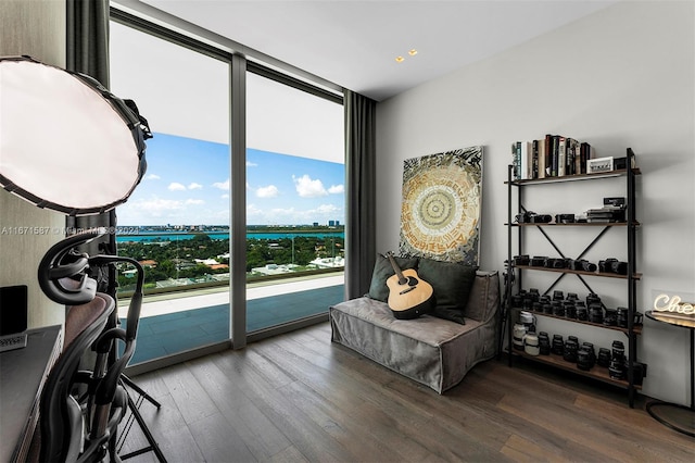 living area featuring wood-type flooring, expansive windows, and a water view