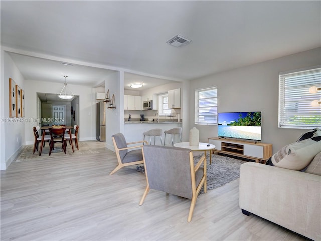 living room with light hardwood / wood-style flooring and sink