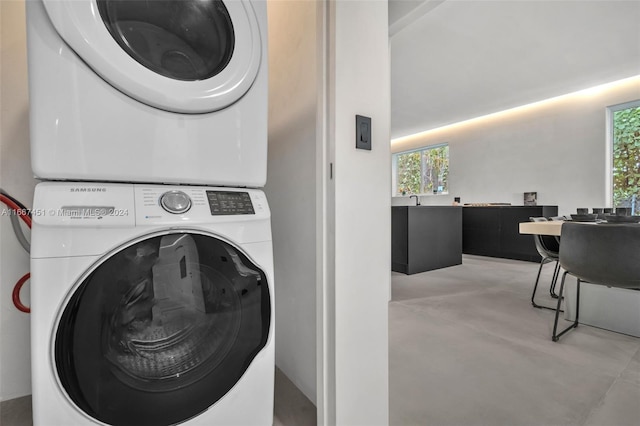 clothes washing area with stacked washer / dryer