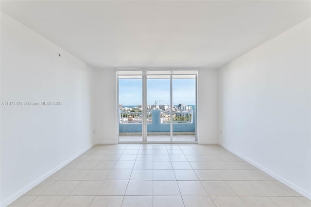 spare room featuring light tile patterned floors and expansive windows