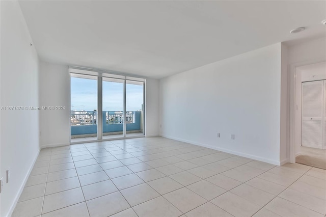 unfurnished room featuring expansive windows and light tile patterned floors