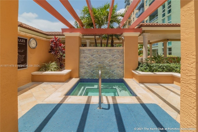 view of swimming pool with a hot tub