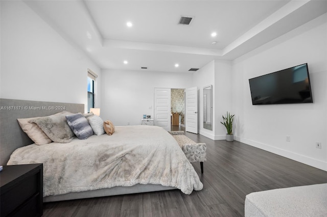 bedroom featuring a tray ceiling and dark wood-type flooring