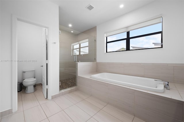 bathroom with tile patterned flooring, toilet, and shower with separate bathtub