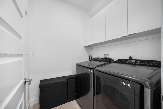 laundry room featuring independent washer and dryer, light tile patterned floors, and cabinets