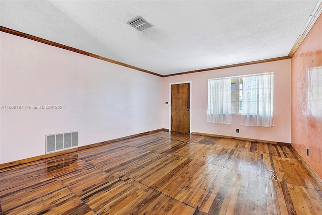 unfurnished room featuring a textured ceiling, ornamental molding, and hardwood / wood-style flooring