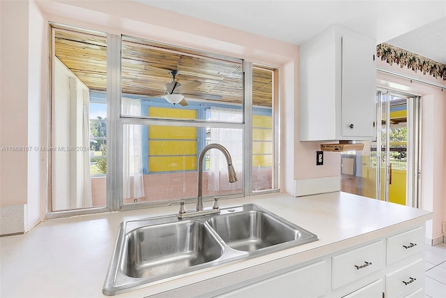 4701 Mainland Dr, Tamarac, FL 33319 - kitchen featuring a sink, white cabinetry, and light countertops