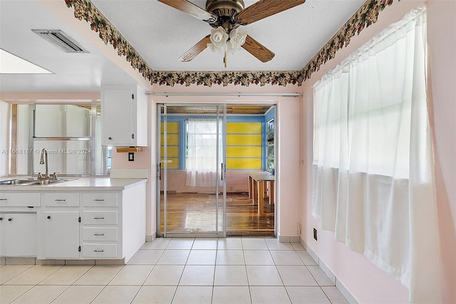 kitchen with white cabinetry, a textured ceiling, ceiling fan, and sink