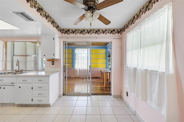 4701 Mainland Dr, Tamarac, FL 33319 - kitchen featuring a sink, ceiling fan, baseboards, white cabinetry, and light tile patterned flooring