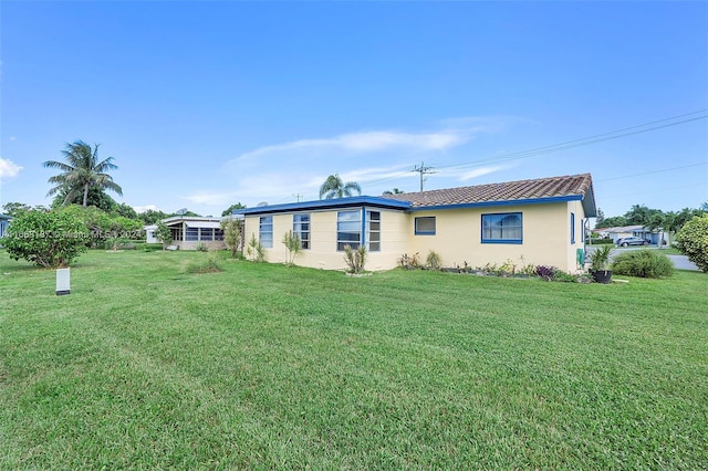 4701 Mainland Dr, Tamarac, FL 33319 - rear view of house featuring stucco siding and a yard