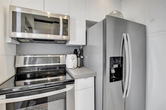 kitchen featuring stainless steel appliances and white cabinetry