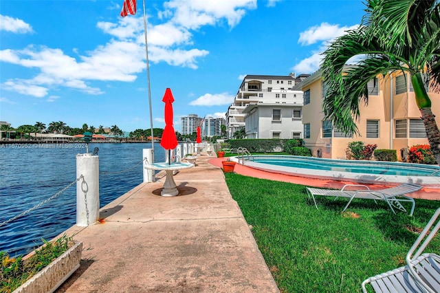 exterior space featuring a water view, a fenced in pool, and a yard