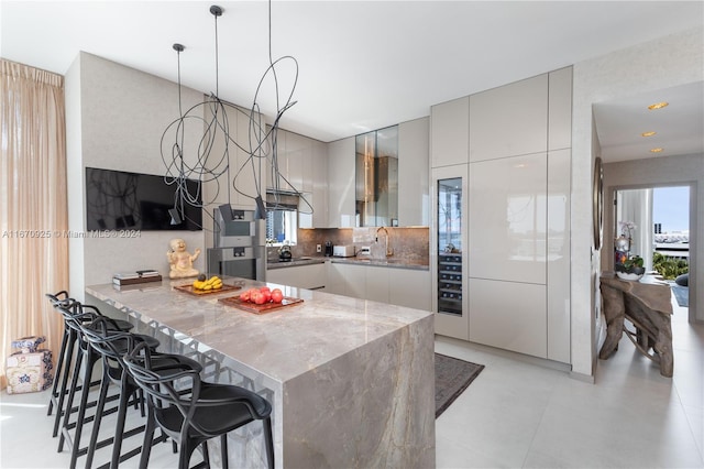 kitchen with kitchen peninsula, a kitchen breakfast bar, decorative backsplash, and a healthy amount of sunlight