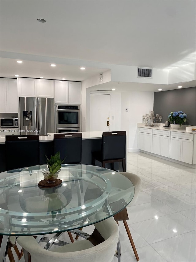 dining area with recessed lighting, visible vents, and marble finish floor
