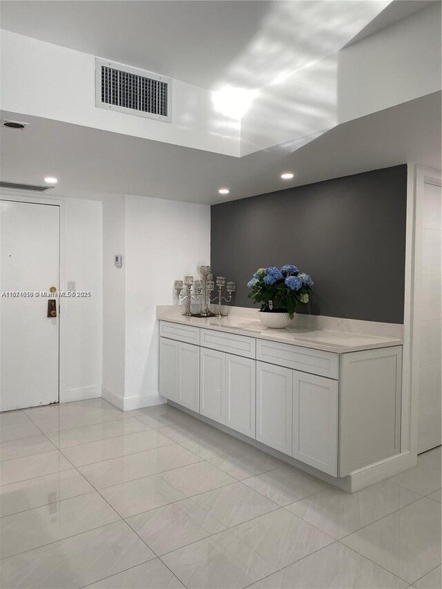 bar featuring light tile patterned flooring, visible vents, recessed lighting, and baseboards