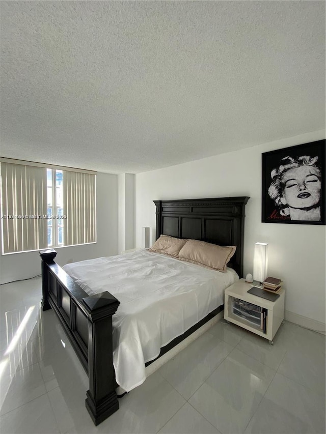 bedroom with tile patterned floors, baseboards, and a textured ceiling