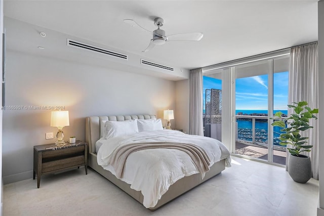 bedroom featuring a water view, ceiling fan, a wall of windows, and access to outside