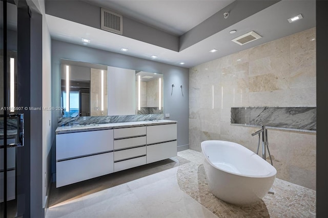 bathroom featuring a bath, tile walls, and vanity