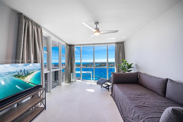 interior space featuring ceiling fan, a wall of windows, and a water view