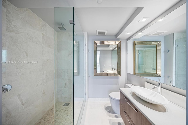 bathroom featuring a tile shower, vanity, and toilet